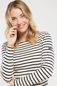 Stribet langærmet skjorte lavet af blødt stof; har marineblå og hvide striber med et lille logo-patch på ærmet.