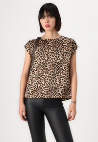 Majica kratkih rukava s leopard uzorkom izrađena od lagane tkanine. Ima slobodan kroj i zaobljeni rub, u kombinaciji s crnim uskim hlačama.