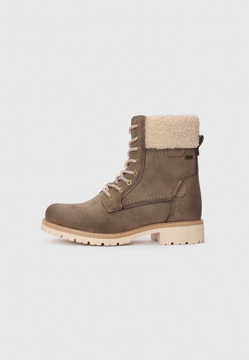 Bottines en cuir brun avec un col en fausse fourrure, bout rond, semelle en caoutchouc clair et œillets métalliques. Design lacé et languette rembourrée.