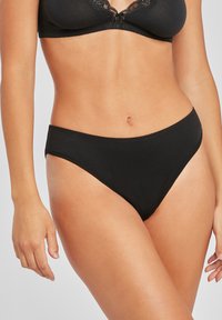 Čierne bikiny s hladkým, elastickým materiálom. Majú minimálne zakrytie s čistým, vysoko strihaným dizajnom a bez viditeľných štítkov.