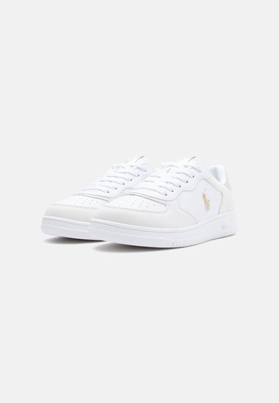 Ζευγάρι λευκά αθλητικά παπούτσια με χαμηλή κορυφή, διάτρητη μύτη, σχέδιο με κορδόνια και χρυσό κεντημένο λογότυπο στο πλάι σε απλό φόντο.