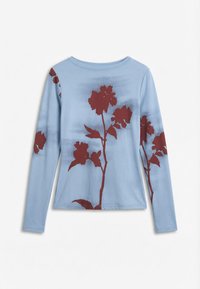 Chemise à manches longues bleu clair avec un col rond, ornée de grands motifs floraux rouge foncé sur le devant et les manches.