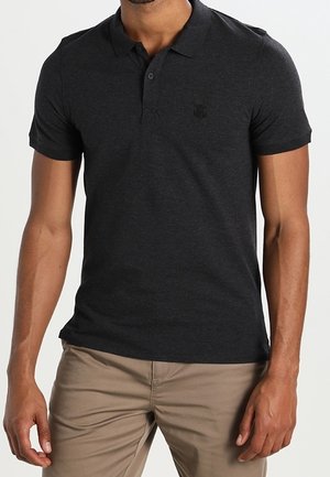 Polo shirt gris foncé en coton, avec un col classique, des manches courtes et un logo discret sur la poitrine. Texture lisse.