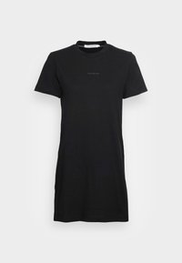 Svart t-shirt klänning med kort ärm gjord av bomull. Har en rund hals och en minimalistisk design med en liten logotyp framtill.