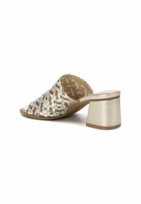 Infradito intrecciato con un design beige chiaro e argento, punta rotonda e un tacco a blocco con una finitura metallica liscia.