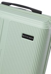 Mint green hard-shell suitcase with a ribbed texture, featuring a black brand label "WITTCHEN" and a dual zipper closure.