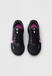 Un paio di scarpe da corsa Nike nere con il logo swoosh rosa e soletta rosa, viste dall'alto su uno sfondo grigio chiaro.