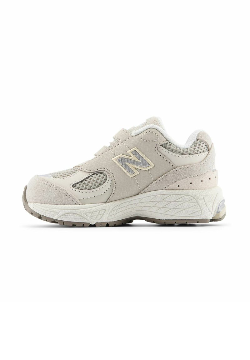 Sneaker featuring a beige suede and mesh upper, prominent "N" logo, cushioned sole, and textured rubber outsole for traction.