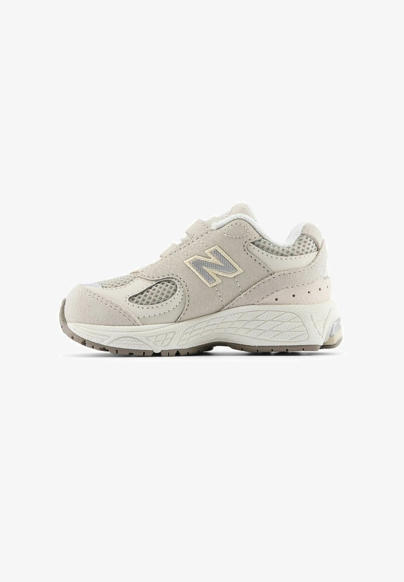 Sneaker featuring a beige suede and mesh upper, prominent "N" logo, cushioned sole, and textured rubber outsole for traction.