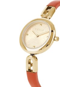 Orologio rotondo color oro con quadrante beige a motivo e dettagli dorati. Presenta un cinturino in pelle corallo con chiusura logata.