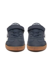 Tmavě modré tenisky s hladkým koženým svrškem, gumovou podrážkou a bílými detaily. Mají tkaničky a suchý zip pro pevné přizpůsobení.