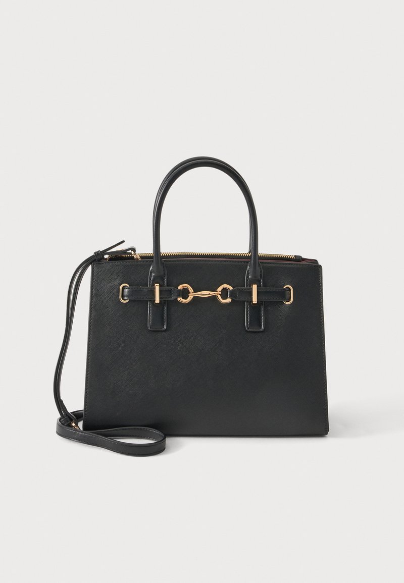 Sac à main structuré noir avec double poignée supérieure, bandoulière amovible, détail mors doré et fermeture éclair sur un fond clair uni.