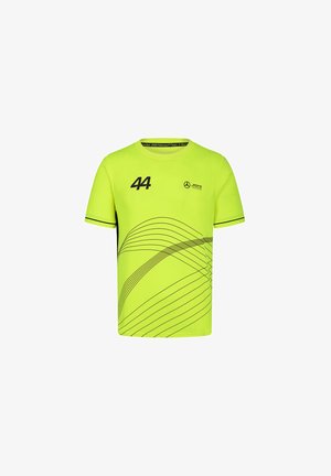 Neon żółta koszulka z krótkim rękawem, z czarnym numerem "44" oraz abstrakcyjnymi wzorami linii. Logo nadrukowane na klatce piersiowej.