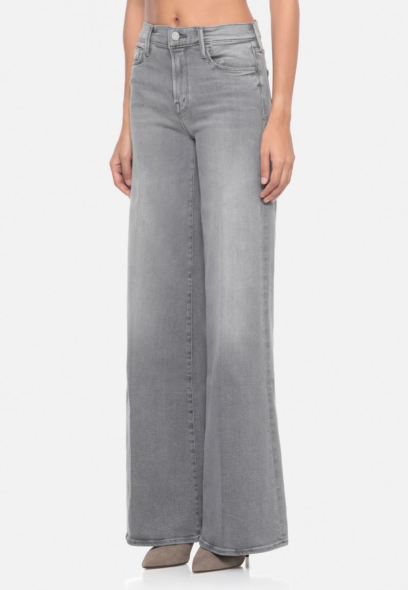 Jeans in denim grigio a gamba larga con vita alta, dotati di chiusura a bottone e tasche frontali. Il tessuto presenta una texture liscia e una leggera sfumatura.