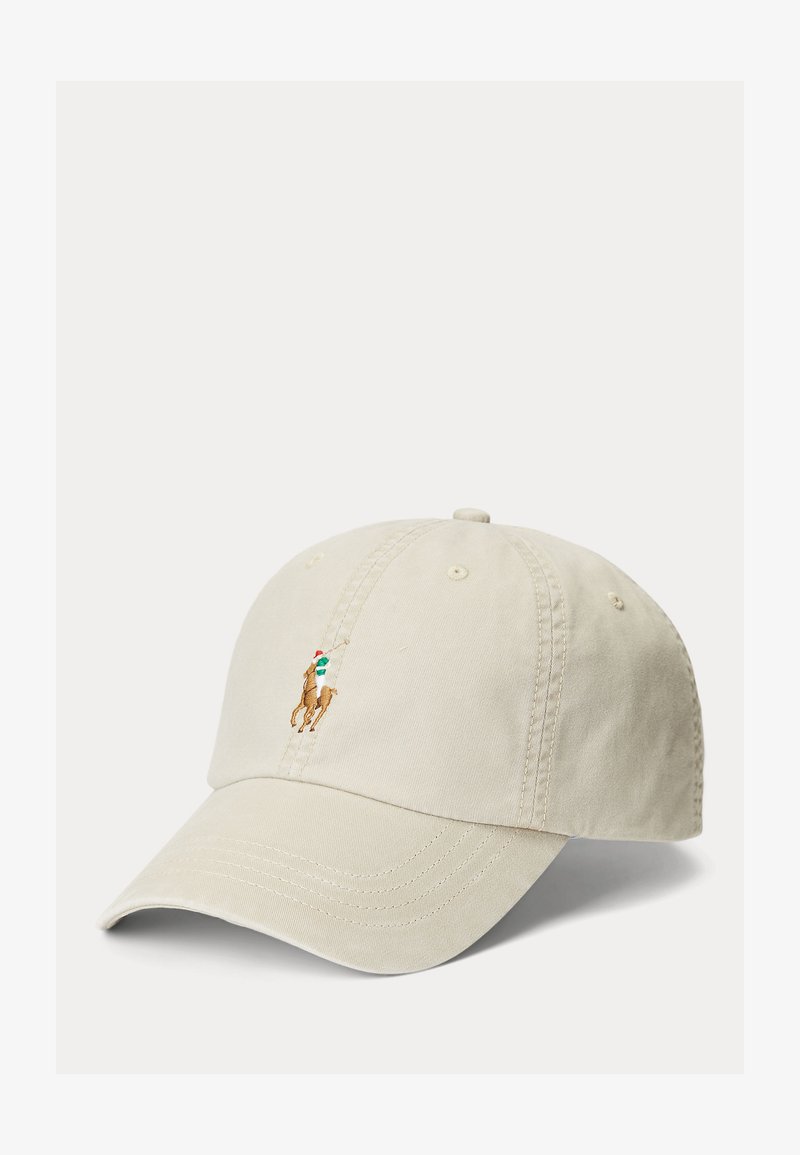 Bež baseball kapa z vezenim logotipom igralca polo v rjavi, zeleni, beli in rdeči barvi na prednjem sredinskem delu.