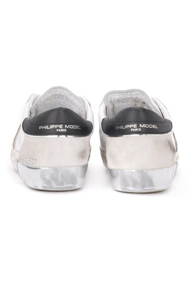 Sneaker bianche in pelle con tacco metallico argentato e dettagli neri. Presentano una parte posteriore testurizzata e un logo impresso sul tacco.