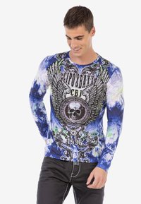 Blaues Langarmshirt mit einem Batikmuster und schwarzen grafischen Designs, einschließlich Flügeln und einem Schädel, aus leichtem Stoff.