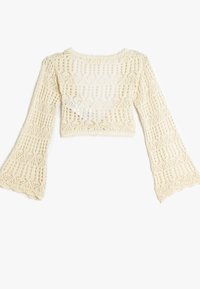 Häkeloberteil in Creme mit langen Glockenärmeln, offenem Muster und gewelltem Saum. Textil mit strukturierter Oberfläche und filigranem Design.