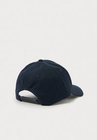 Navy blue cotton baseball cap with a curved visor, adjustable strap at the back, and ventilation eyelets. Simple design with no patterns.