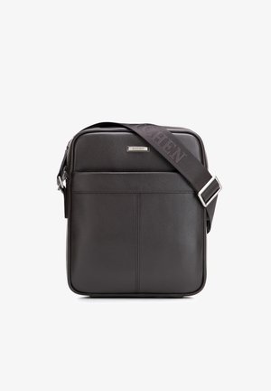 Czarna skórzana torba na ramię z przednią kieszenią, regulowanym szerokim paskiem oraz srebrną metką marki z napisem "WITTCHEN".