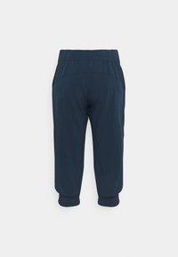 Pantalones de chándal azul marino con cinturilla elástica, piernas ajustadas y puños de canalé. Tejido suave con un diseño elegante y simple.
