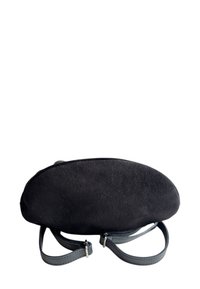 Černá semišová kabelka s kulatým tvarem, která má dvě nastavitelné kožené uši a decentní stříbrné hardware. Texturovaný povrch.