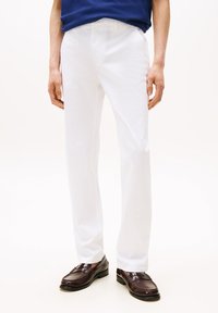Λευκό βαμβακερό παντελόνι με σχεδιασμό ίσιου ποδιού. Διαθέτει κλασική μέση και συνδυάζεται με καφέ δερμάτινα μοκασίνια. Απλό και καθαρό στυλ.