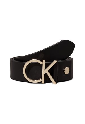 Ceinture en cuir noir avec une boucle en métal doré en forme des lettres "CK" et un petit détail rond doré près de la boucle.