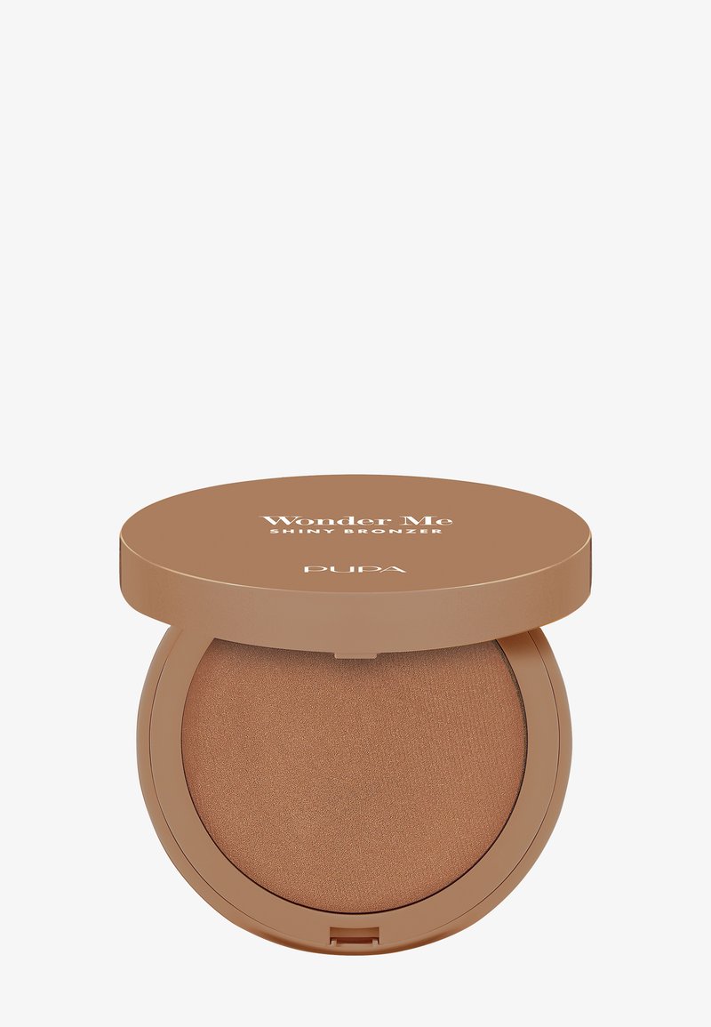 Polvo bronceador en un estuche compacto y redondo con una tapa brillante de color marrón claro, con el texto "Wonder Me Shiny Bronzer" y una superficie bronceada lisa.