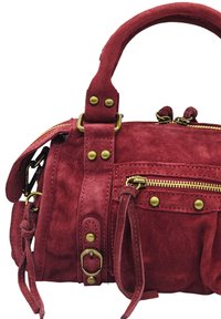 Sac à main en daim rouge avec quincaillerie en laiton, double poignées supérieures, poches zippées à l'avant et couture décorative. Présente une finition texturée.