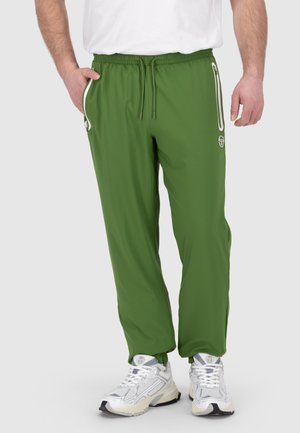 Groene sportbroek van lichtgewicht materiaal, met een elastische tailleband, trekkoord en zijzakken met rits en witte accenten.