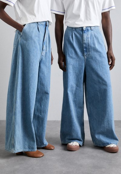 Lysblå denim jeans med vide ben, højt liv, kontraststikninger, for- og baglommer samt knaplukning.