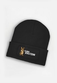 Black knit beanie with ribbed texture, featuring a cartoon rabbit design and the text “KLEINES SCHLITZOHR” on a rectangular patch.