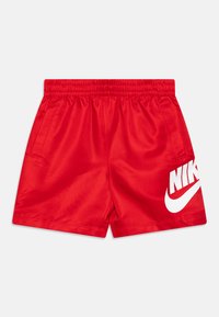 Červené športové šortky vyrobené z hladkej tkaniny, s elastickým pásom, bočnými vreckami a veľkým bielym logom Nike na ľavom stehne.