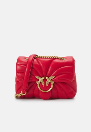Rote Lederhandtasche mit gesteppter Design, goldenen Metallakzenten mit zwei Vögeln und einer Kettenriemen. Kompakte und strukturierte Form.