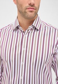 Gestreept shirt met verticale lijnen in tinten van wit, lichtbruin en bordeauxrood, met een knoopsluiting kraag en witte knopen.