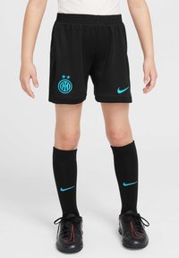 Crne nogometne kratke hlače s plavim Nike logotipom i grbom Inter Milana, ukrašene s dvije zvijezde. Uparene s crnim čarapama do koljena i crnim kopačkama.