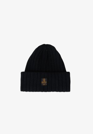 Zwarte gebreide beanie met een geribbeld uiterlijk en een opgerolde rand, met een klein rechthoekig label met een hondenlogo in geel en zwart.