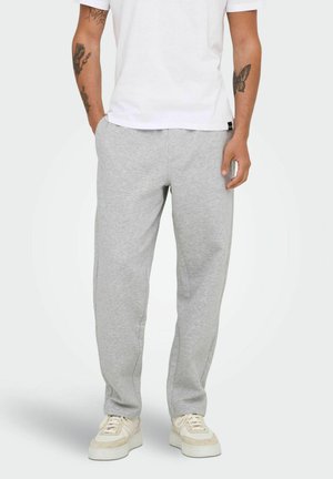 Light gray cotton sweatpants with a relaxed fit, featuring side pockets and smooth texture, paired with white sneakers and a plain white t-shirt.