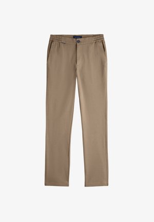 Pantalons beige slim-fit avec ceinture élastique, fermeture à bouton, poches latérales et étiquette de marque à la taille.