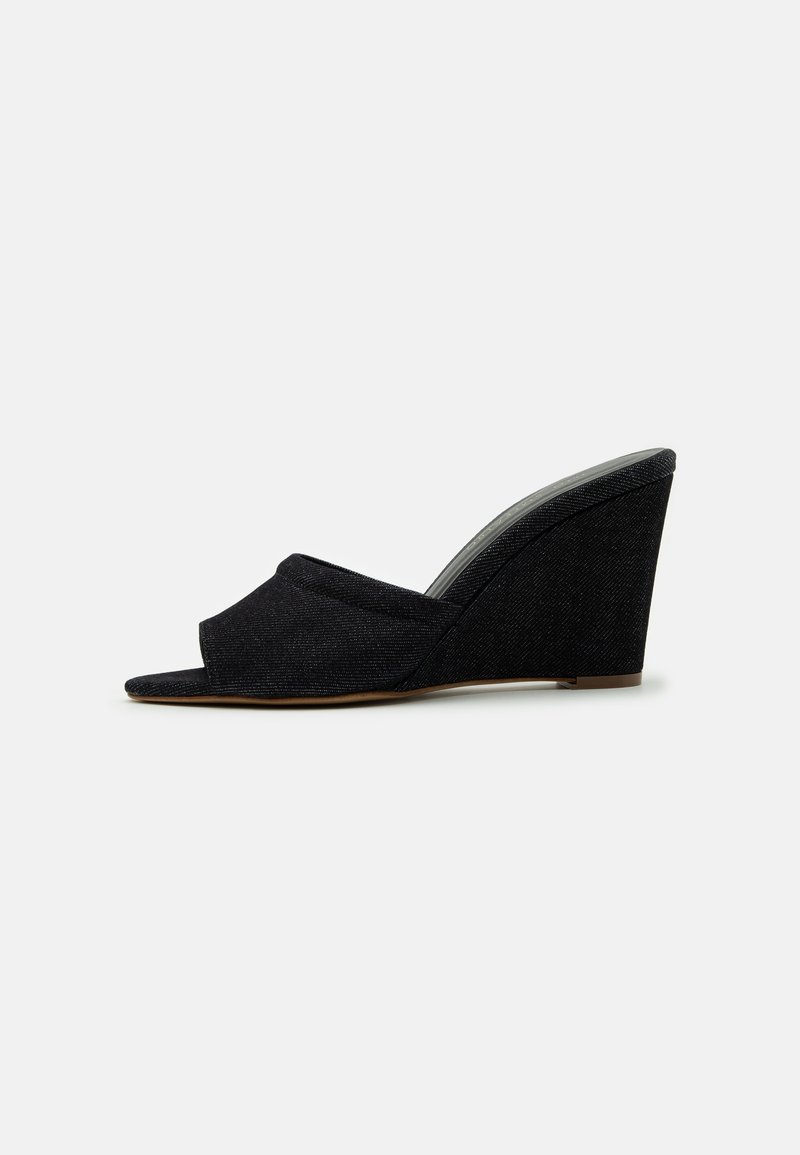 Black wedge sandal featuring an open toe and a curved, fabric upper with a textured finish. The wedge heel is approximately 8 cm tall.