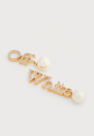Σκουλαρίκια σε χρυσαφί απόχρωση που σχηματίζουν τη λέξη "Off-White" με ενσωματωμένους κρυστάλλους και προσκολλημένες μεγάλες λευκές ψεύτικες πέρλες σε λευκό φόντο.