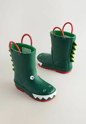 Grüne Gummistiefel mit Krokodillederstruktur, Details mit weißen Zähnen, großen Augen, roten Griffen und roten Sohlen; verfügen über stachelige Akzente an der Rückseite.