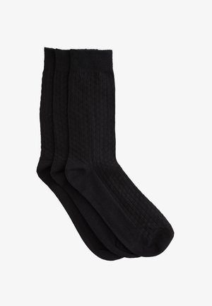 Lot de trois chaussettes noires avec un texture côtelée et un design uni. Le mélange de coton offre confort et durabilité.