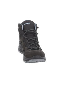 Stivale da trekking nero con tomaia in suede e rete, punta rinforzata, suola in gomma grigia e lacci piatti con dettagli riflettenti.