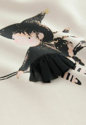 Cotton fabric with a printed witch character in black and peach tones. Features a textured black ruffle at the hem, adding detail.