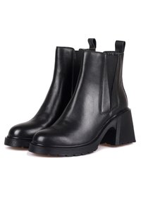 Paire de bottines en cuir noir avec talons hauts épais, panneaux latéraux élastiques et languettes à l'arrière, sur fond blanc.