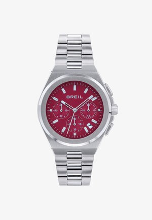 Montre chronographe en acier inoxydable argenté avec un cadran rouge, des index blancs et un affichage de la date ; présente un design de bracelet articulé.