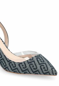 Escarpin en tissu à motifs bleus avec un bout pointu, une insert transparente sur le côté et un intérieur beige. Texture lisse et design de talon fin.