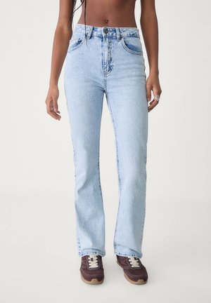 Light blue, high-waisted denim jeans with a flared leg and subtle faded wash. Features front pockets and a zip fly with a button closure.